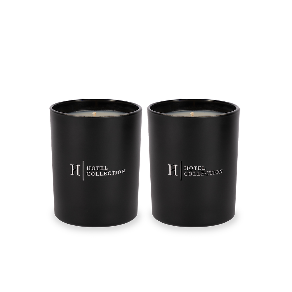 A pair of black candles with the word hotel collection on them.