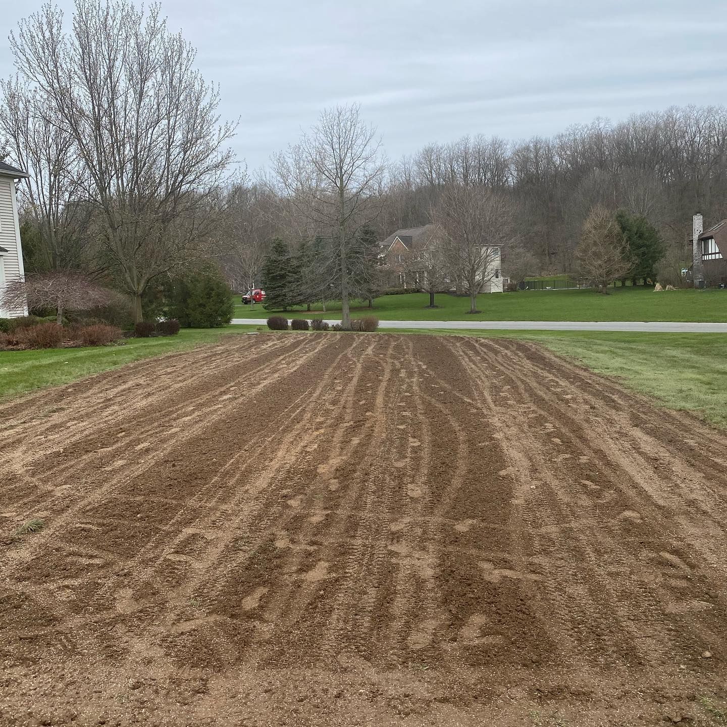 A large dirt field with a house in the background