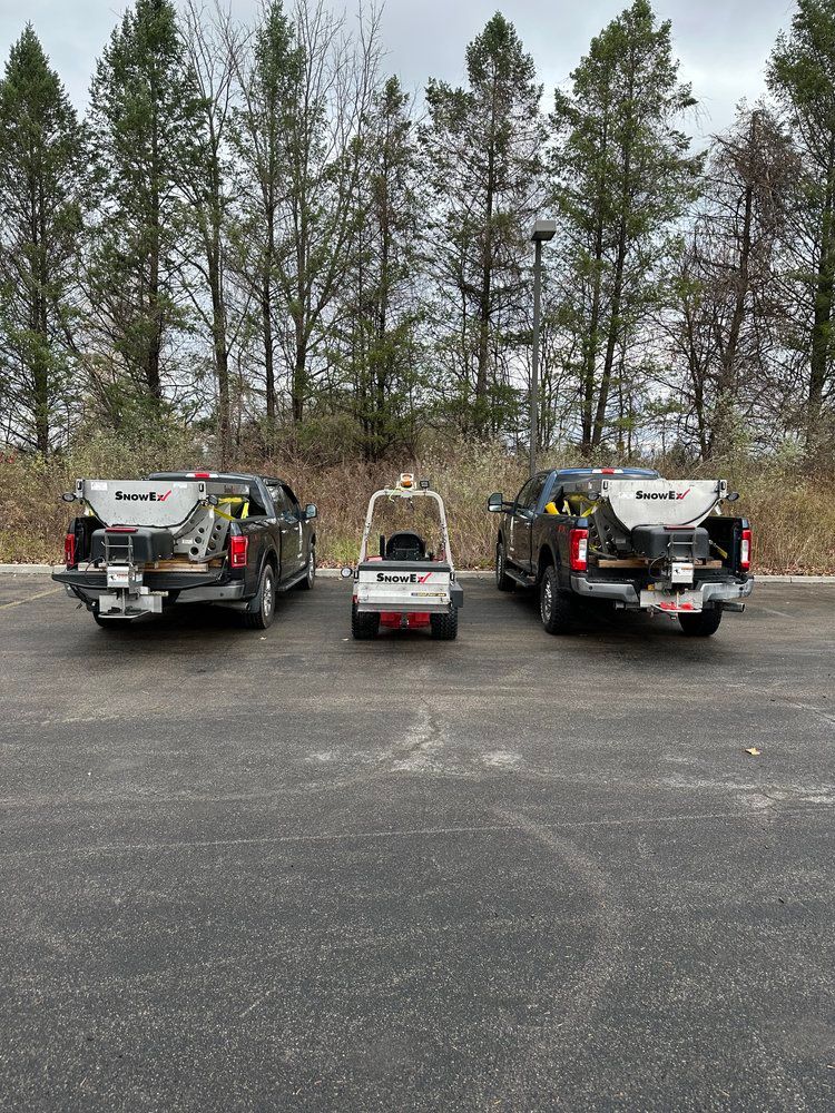 Three trucks are parked next to each other in a parking lot.