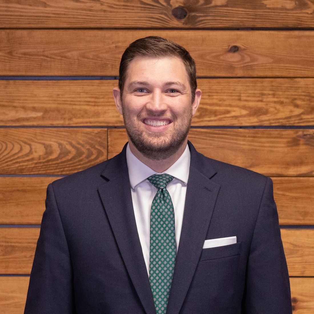 A man in a suit and tie is smiling for the camera.