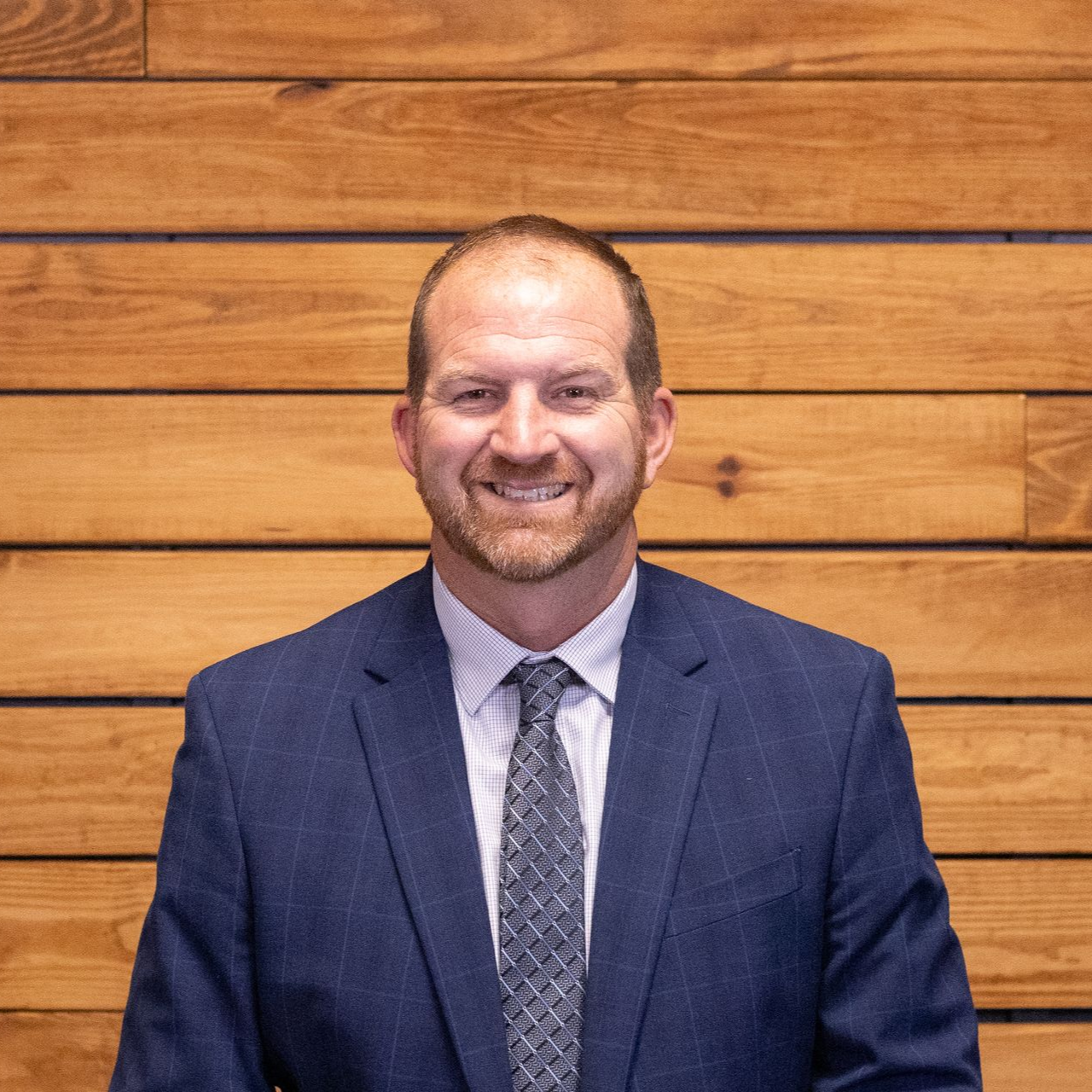 A man in a suit and tie is smiling for the camera.
