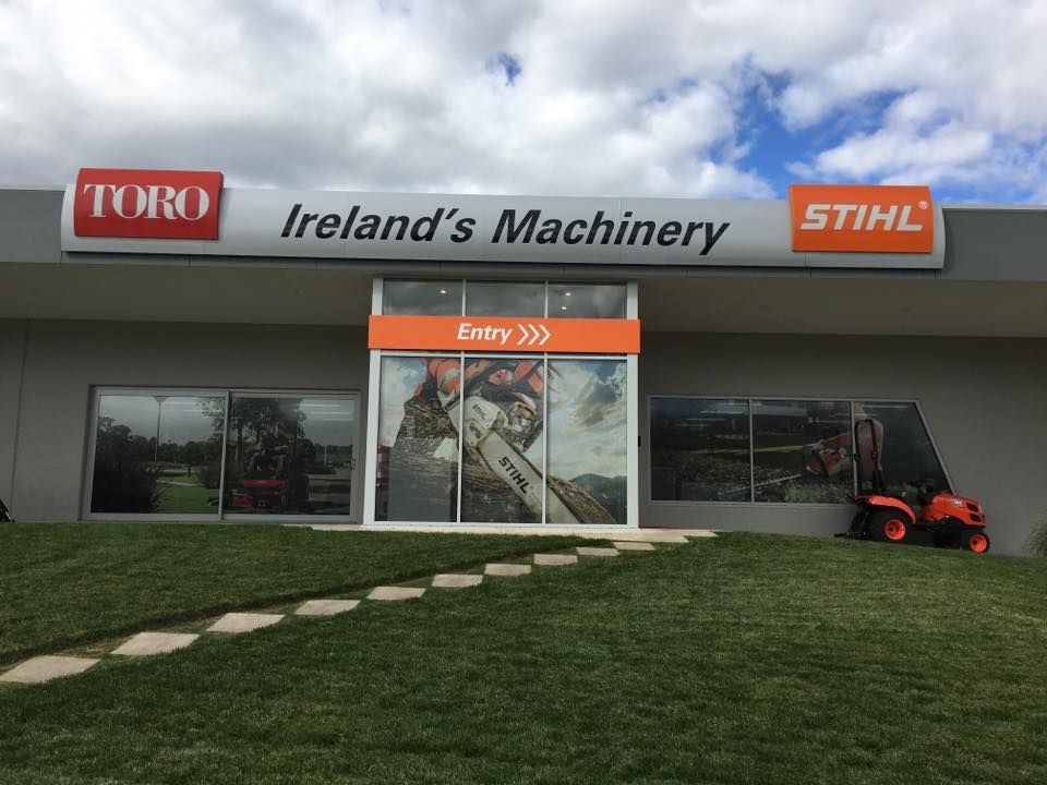 A Tractor Is Parked In Front Of A Building That Says Ireland 's Machinery — Ireland's Machinery Pty Ltd In Braemar, NSW
