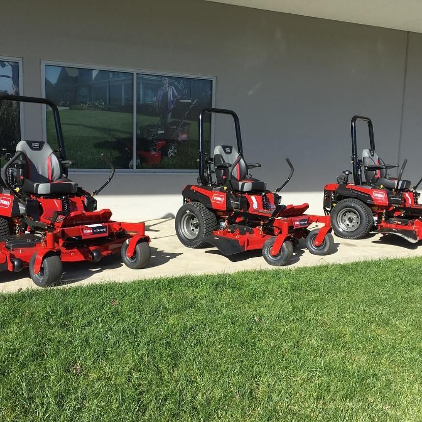 Three Red Lawn Mowers Are Parked in Front of a Building — Ireland's Machinery Pty Ltd In Braemar, NSW