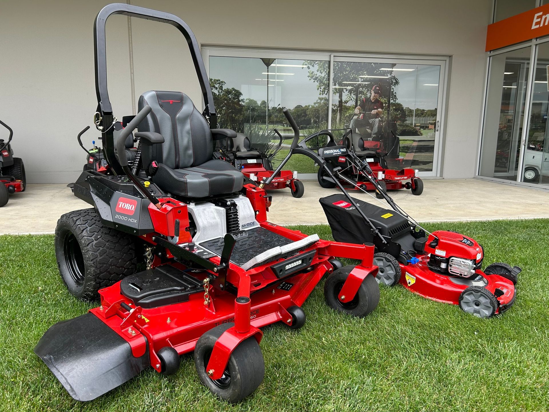 Two Red Mowers In Front Of a Shop — Ireland's Machinery Pty Ltd in Braemar, NSW