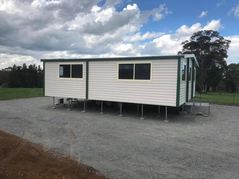 A White House With Green Trim is Sitting in a Gravel Lot — Ireland's Machinery Pty Ltd In Braemar, NSW