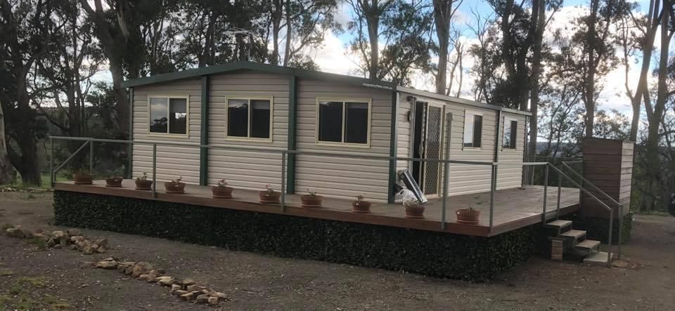 A Small House With a Deck in the Middle of a Forest — Ireland's Machinery Pty Ltd In Braemar, NSW