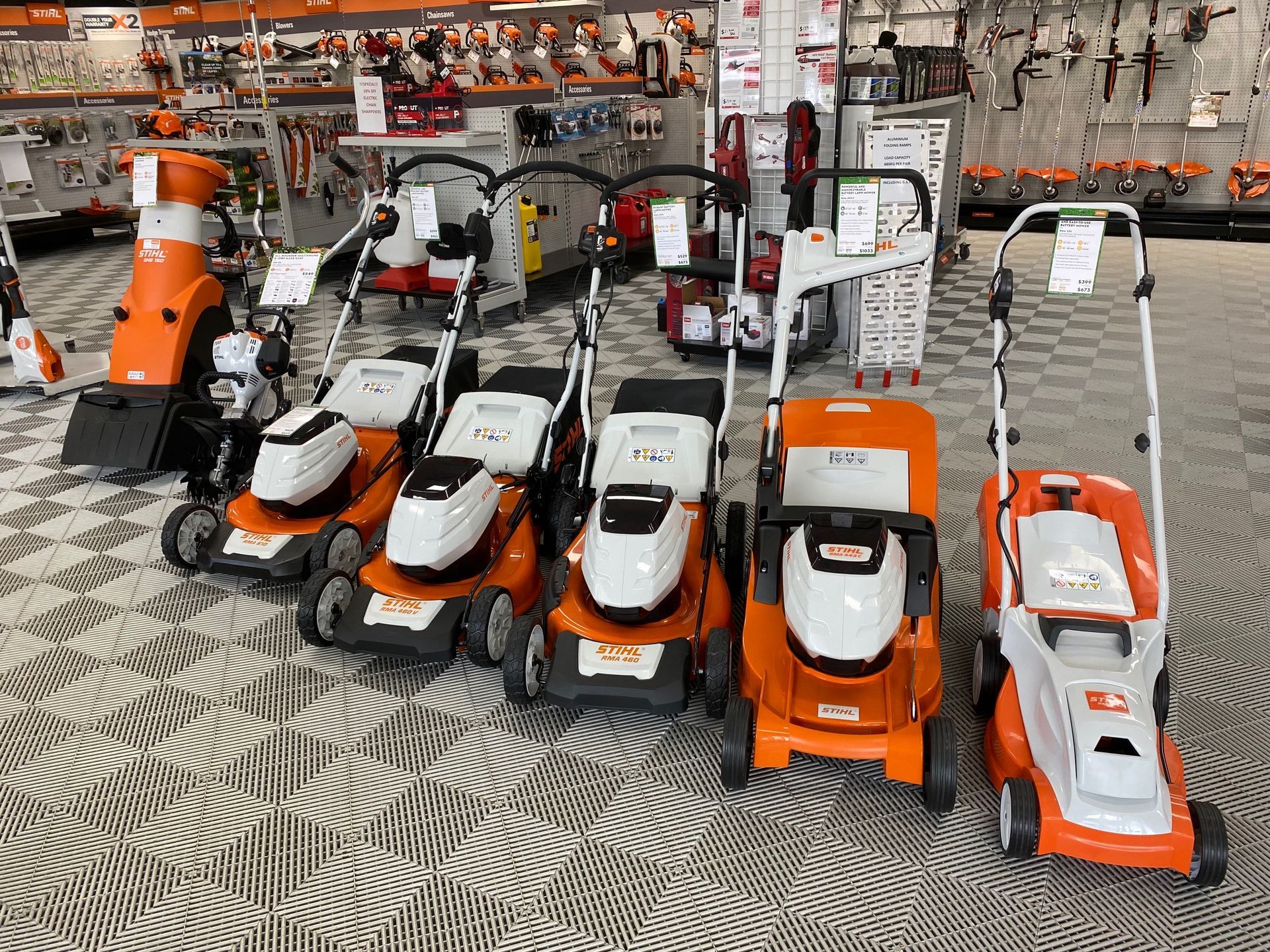 A Line Up of Orange Push Mowers on Display in a Shop — Ireland's Machinery Pty Ltd in Braemar, NSW