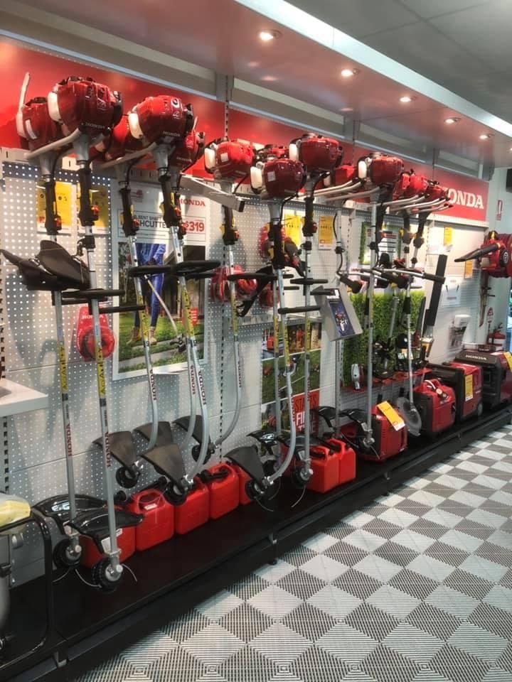 A Row of Lawn Mower and Gas Cans in a Store — Ireland's Machinery Pty Ltd In Braemar, NSW