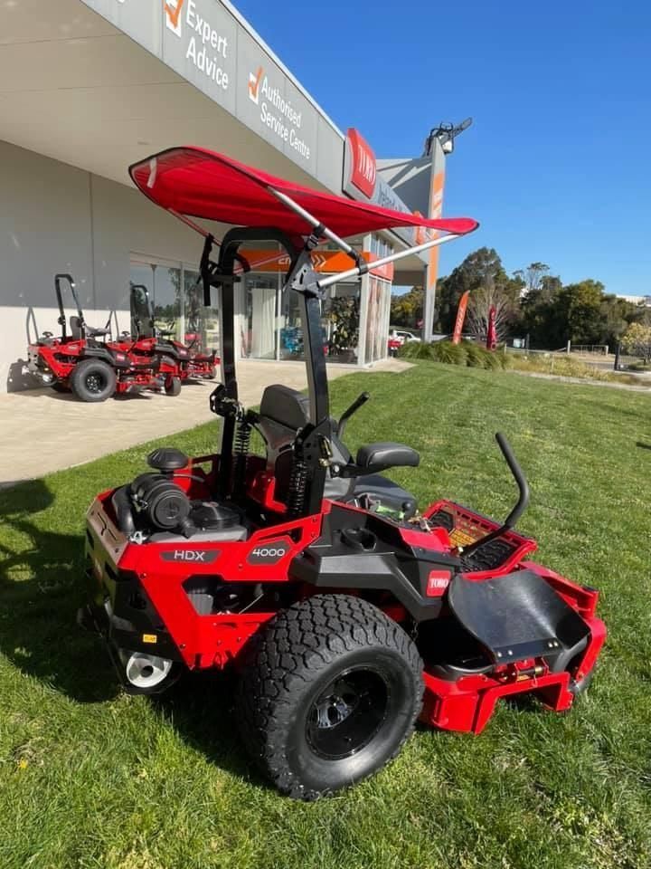 A Red Lawn Mower is Parked in Front of a Building — Ireland's Machinery Pty Ltd In Braemar, NSW