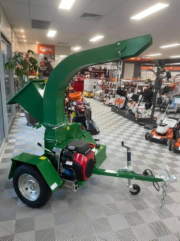 A Green Tree Chipper is Sitting on a Trailer in a Store — Ireland's Machinery Pty Ltd In Braemar, NSW