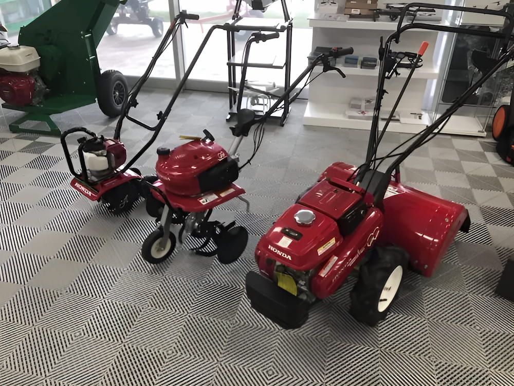 Three Red Lawn Mowers Are Sitting on a Checkered Floor in a Showroom β Ireland's Machinery Pty Ltd In Braemar, NSW
