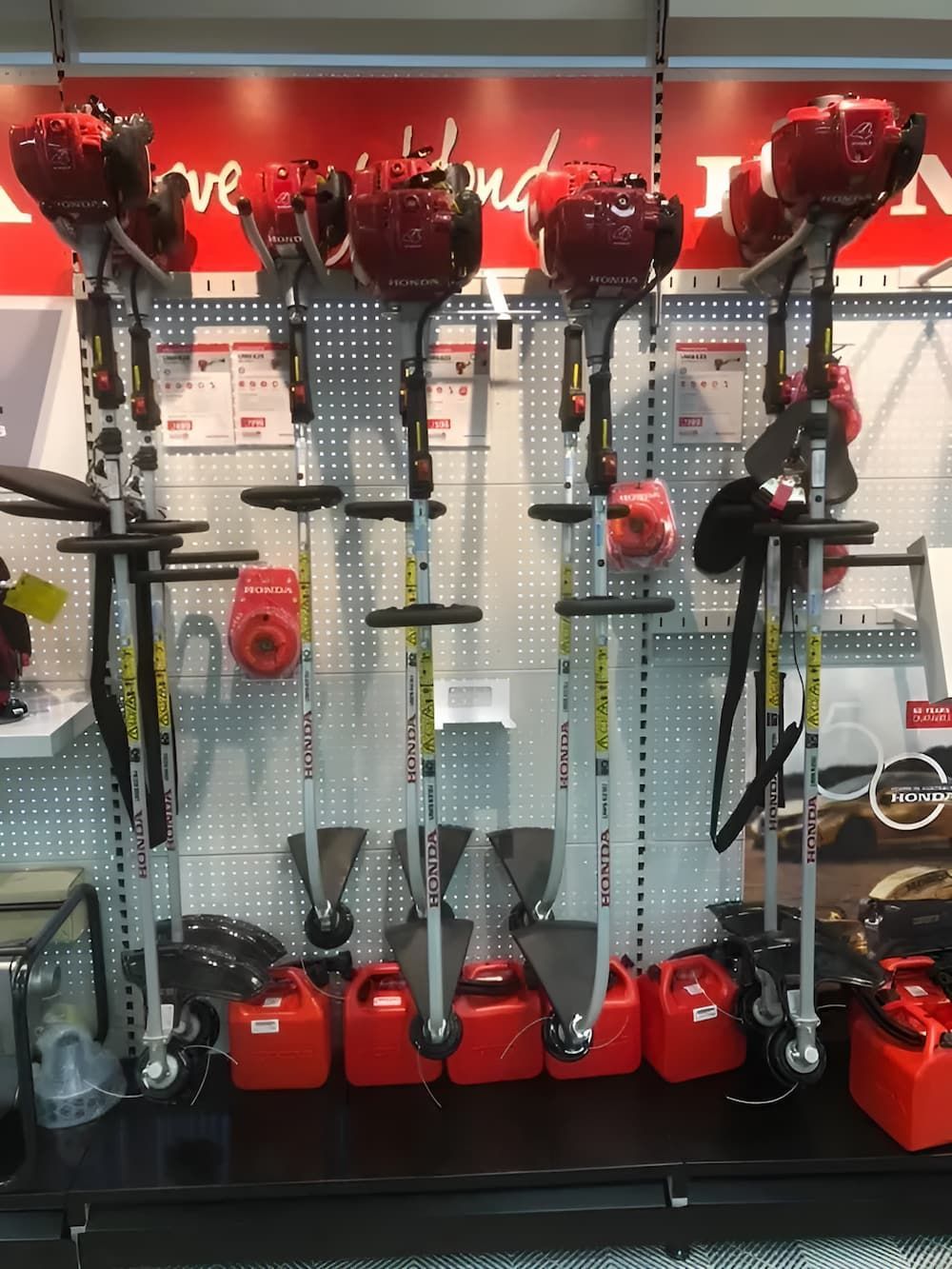A Row Of Lawn Mower 's Are Lined Up On A Shelf In A Store — Ireland's Machinery Pty Ltd In Braemar, NSW