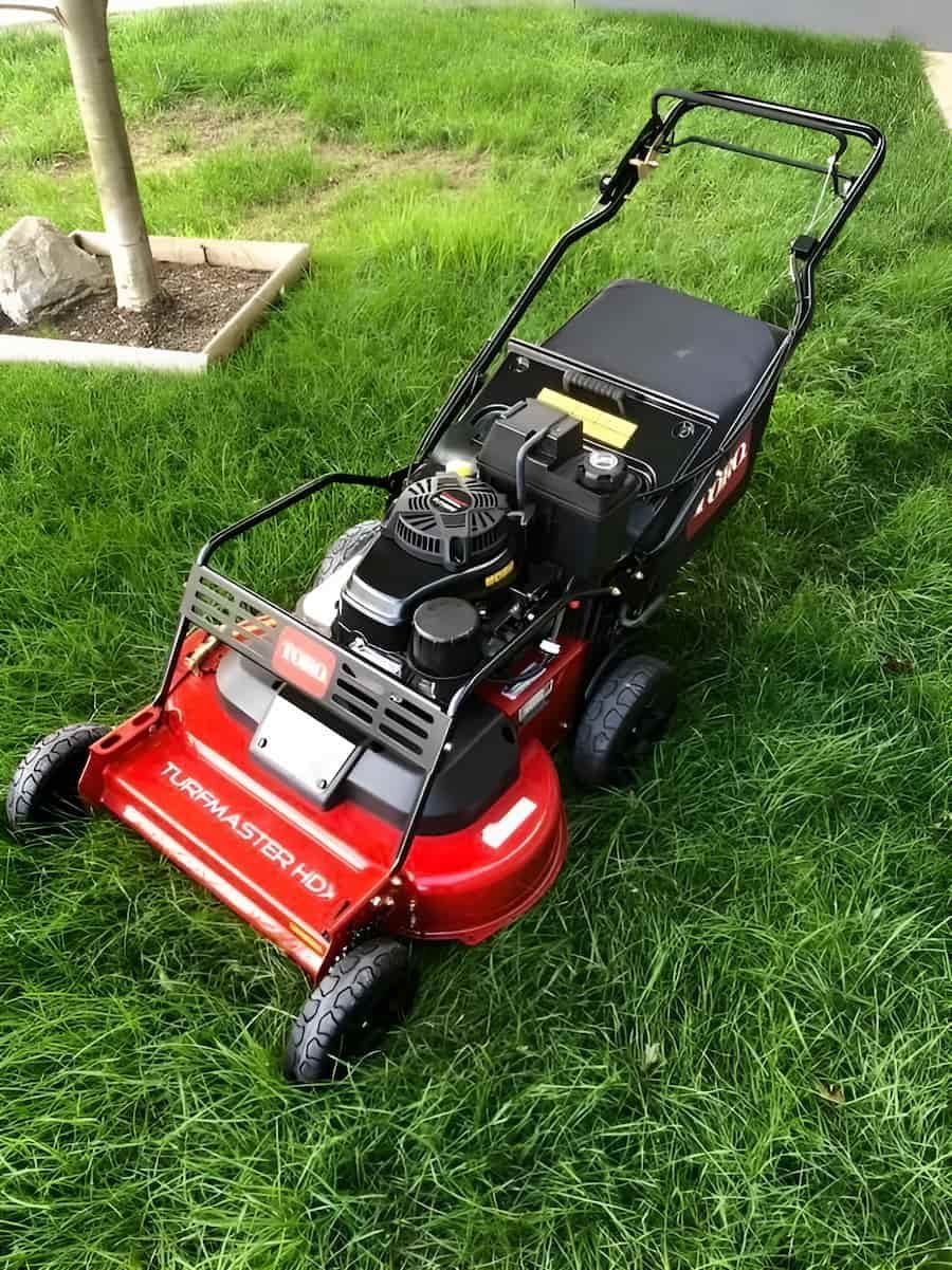 A Red Lawn Mower is Sitting on Top of a Lush Green Lawn — Ireland's Machinery Pty Ltd in Braemar, NSW