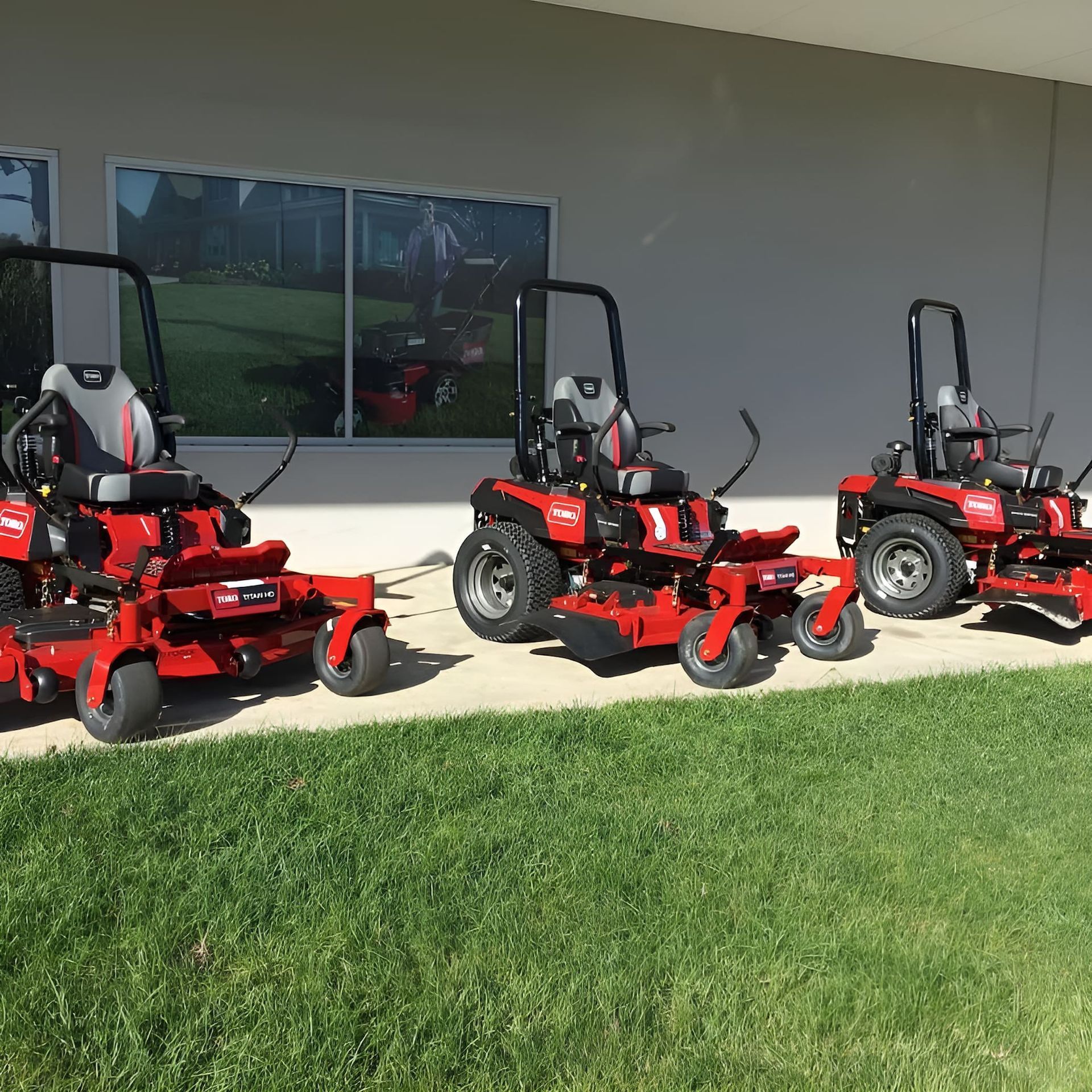 Three Red Lawn Mowers Are Parked in Front of a Building — Ireland's Machinery Pty Ltd In Braemar, NSW