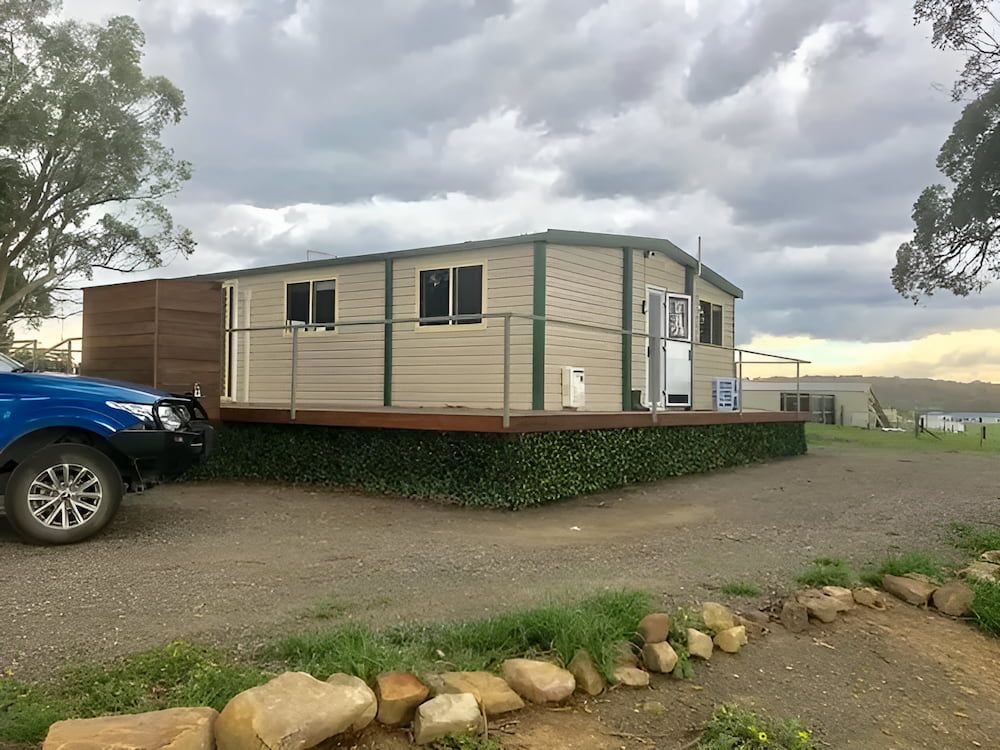 A Blue Truck is Parked in Front of a Small House — Ireland's Machinery Pty Ltd In Braemar, NSW