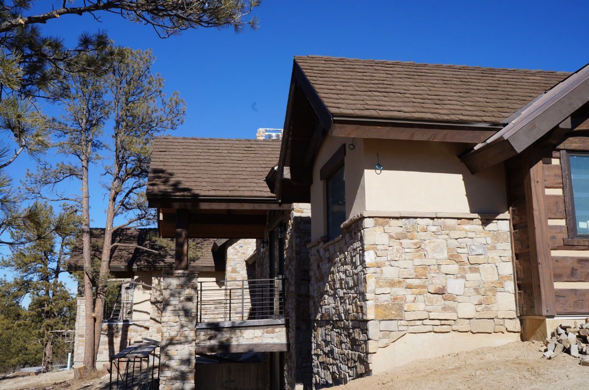 a large stone house with a brown roof is sitting on top of a hill .