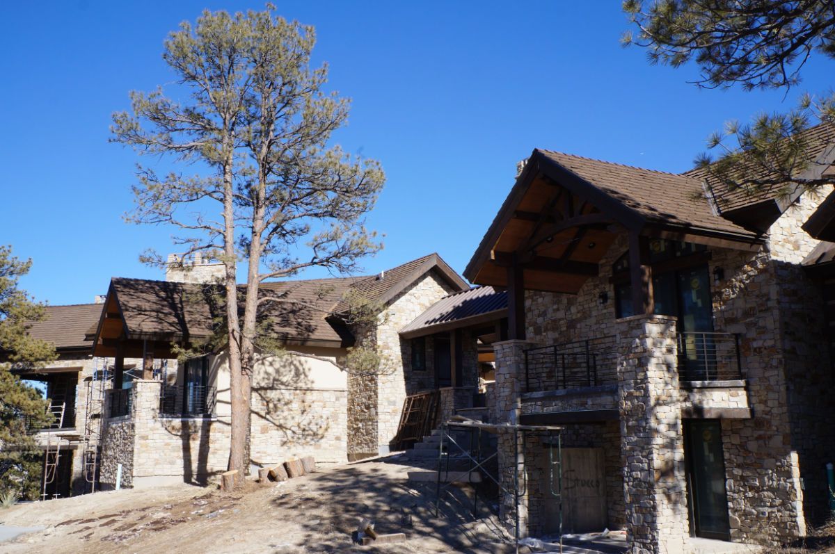 a couple of houses sitting next to each other on top of a hill .