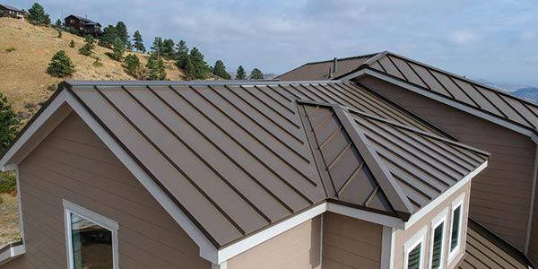 a house with a metal roof is sitting on top of a hill .