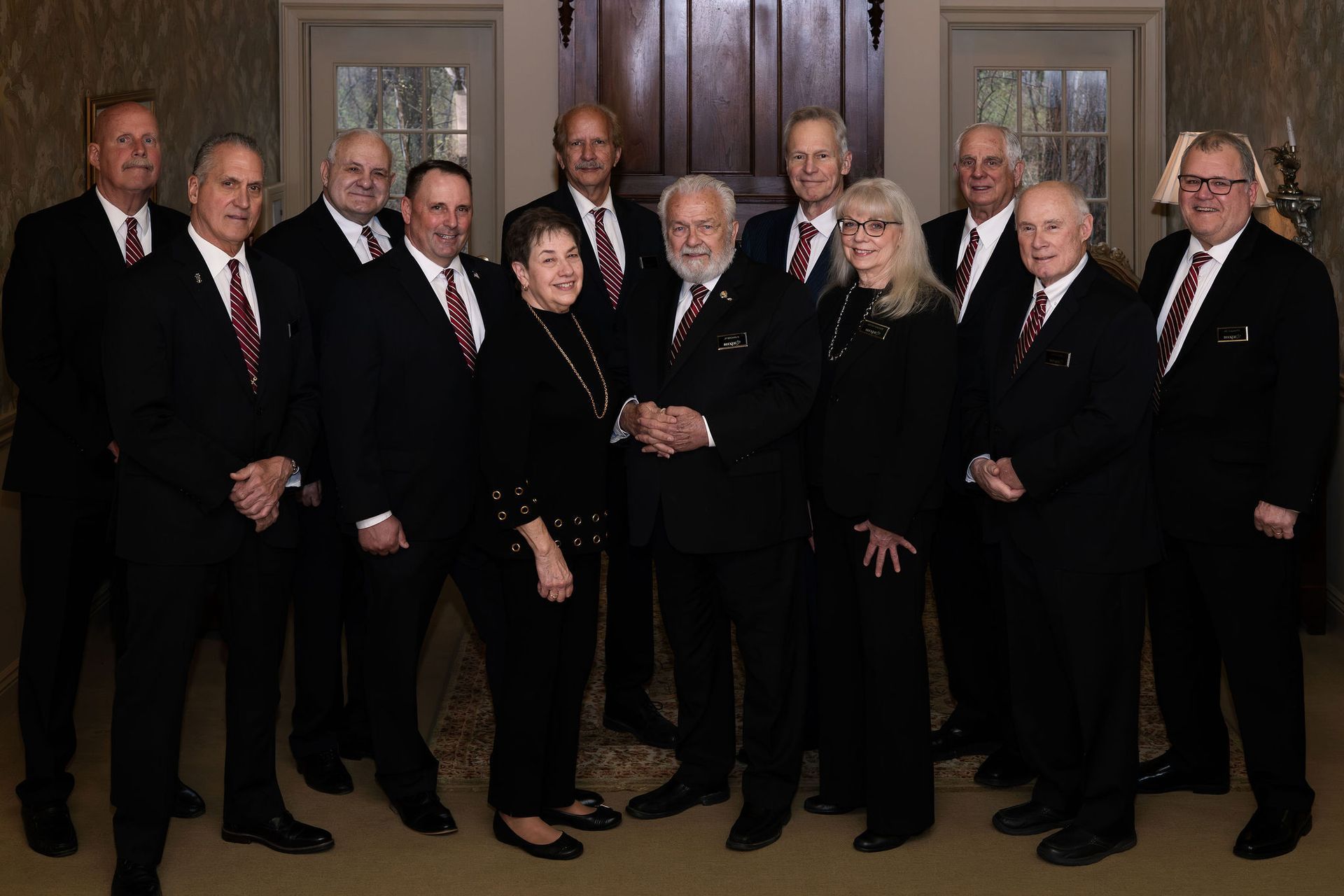 A group of people in suits and ties are posing for a picture.