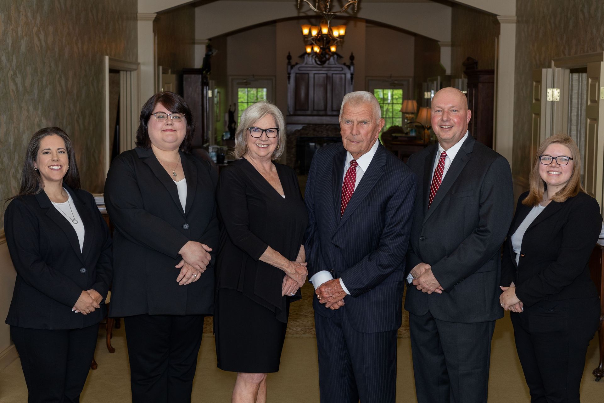 A group of people in suits and ties are posing for a picture.