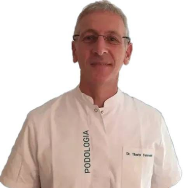 Podologo sorridente con occhiali e camice bianco con la scritta