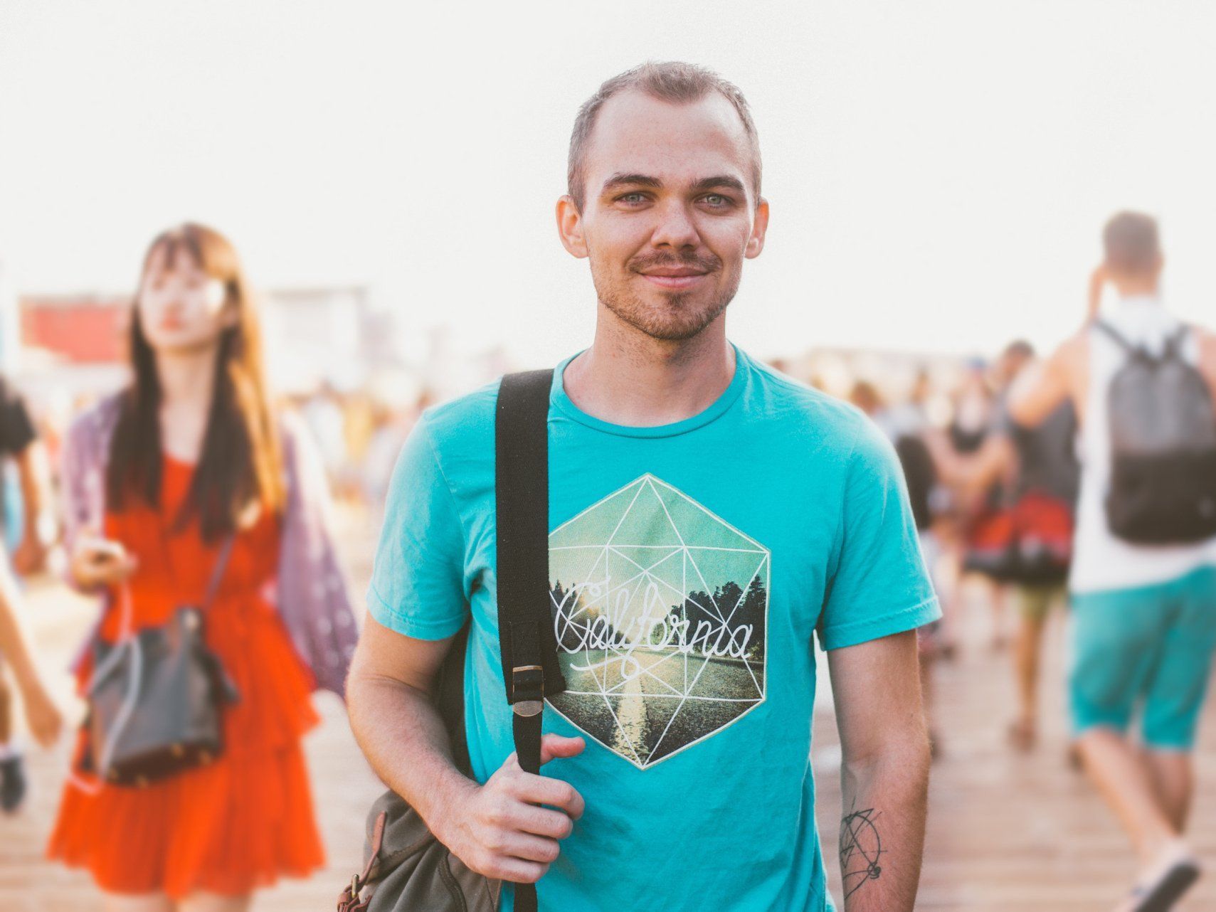 A man in a blue t-shirt is standing in front of a crowd of people.