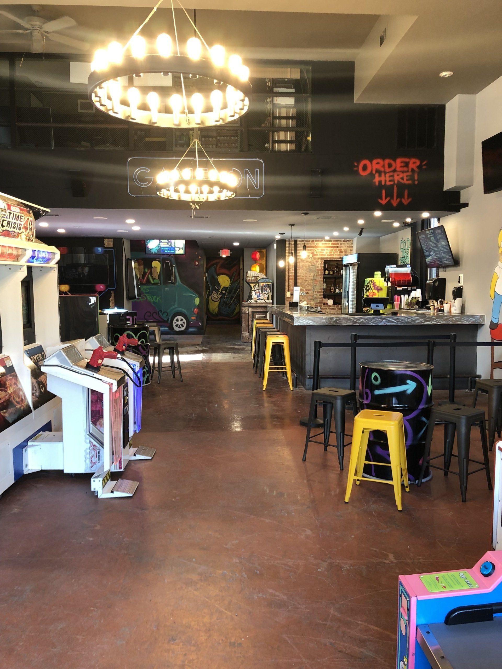 A large room with a lot of arcade games and a sign that says order here