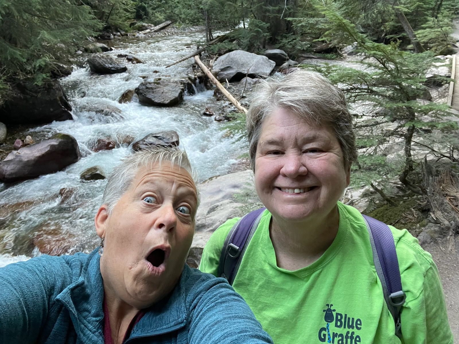 Two women are taking a selfie in front of a river.