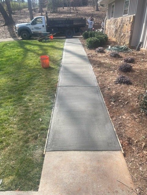 A concrete walkway is being built in front of a house.