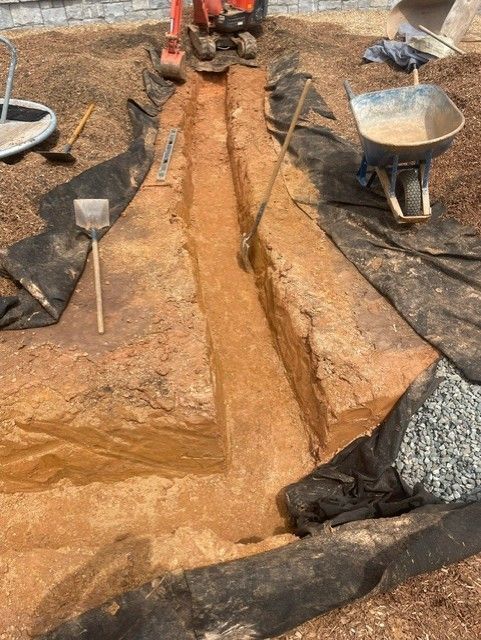 A wheelbarrow filled with dirt is sitting on top of a pile of dirt.