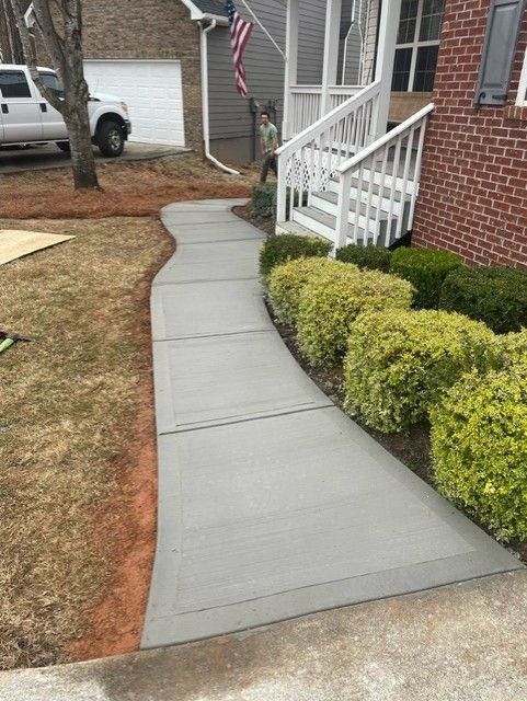 A concrete walkway leading to the front door of a house.