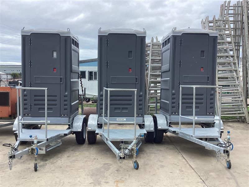 Three Large Gray Utility Cabinets on Wheeled Trailers Parked Outdoors Under Cloudy Skies — Bowen Hire in Bowen, QLD