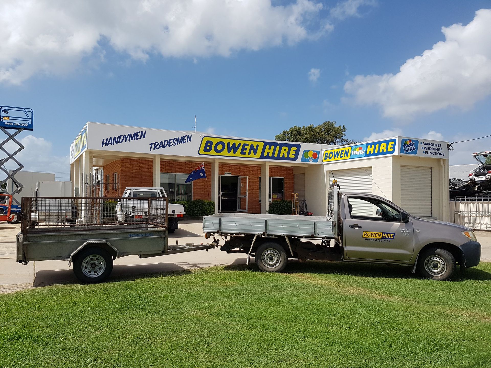Bowen Hire Storefront With Two Utility Trucks Parked on Grass Under a Blue Sky — Bowen Hire in Bowen, QLD
