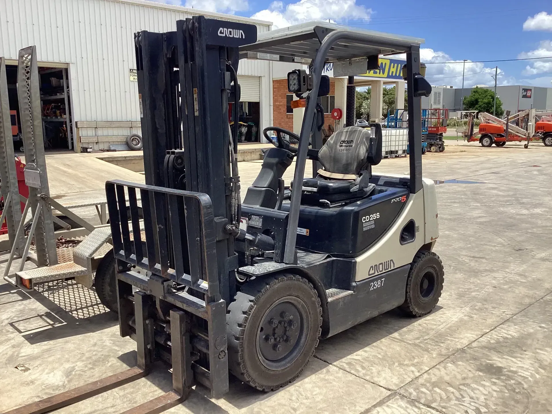 White Forklift Parked on A Concrete Lot Beside a Warehouse — Bowen Hire in Proserpine, QLD