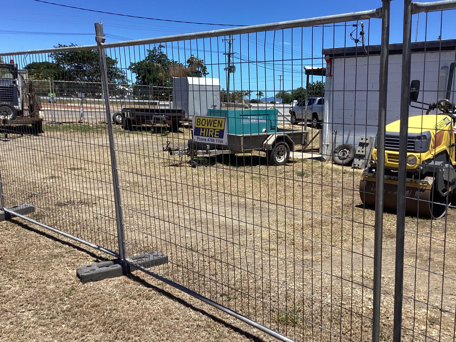 Temporary Construction Fencing Around a Dirt Lot With Parked Utility Vehicles — Bowen Hire in Bowen, QLD