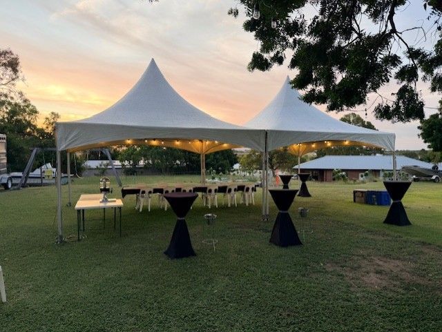 Outdoor Event Tent with Cocktail Tables on A Grassy Lawn at Sunset — Bowen Hire in Proserpine, QLD