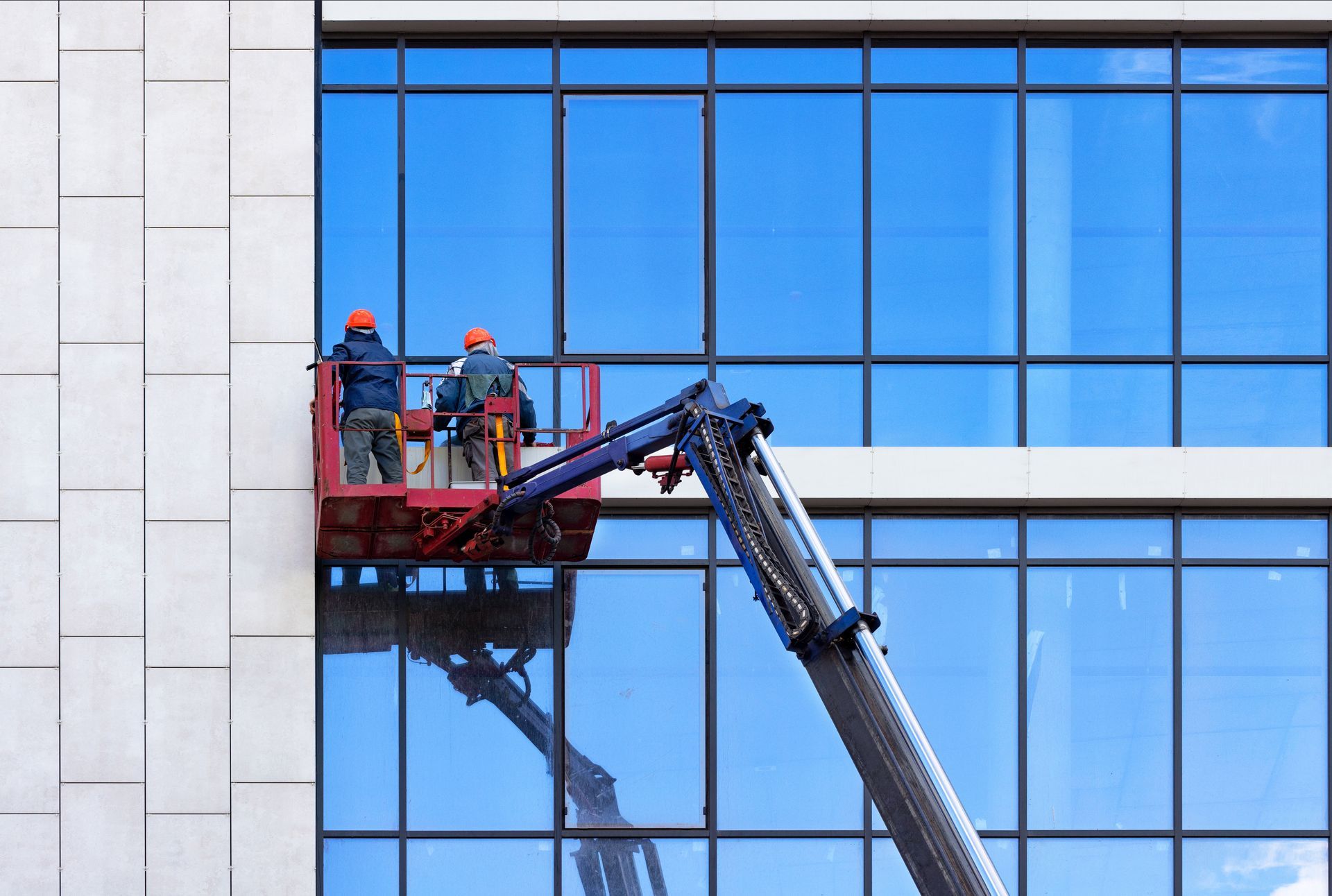 two professional window cleaners cleaning a commercial building's windows