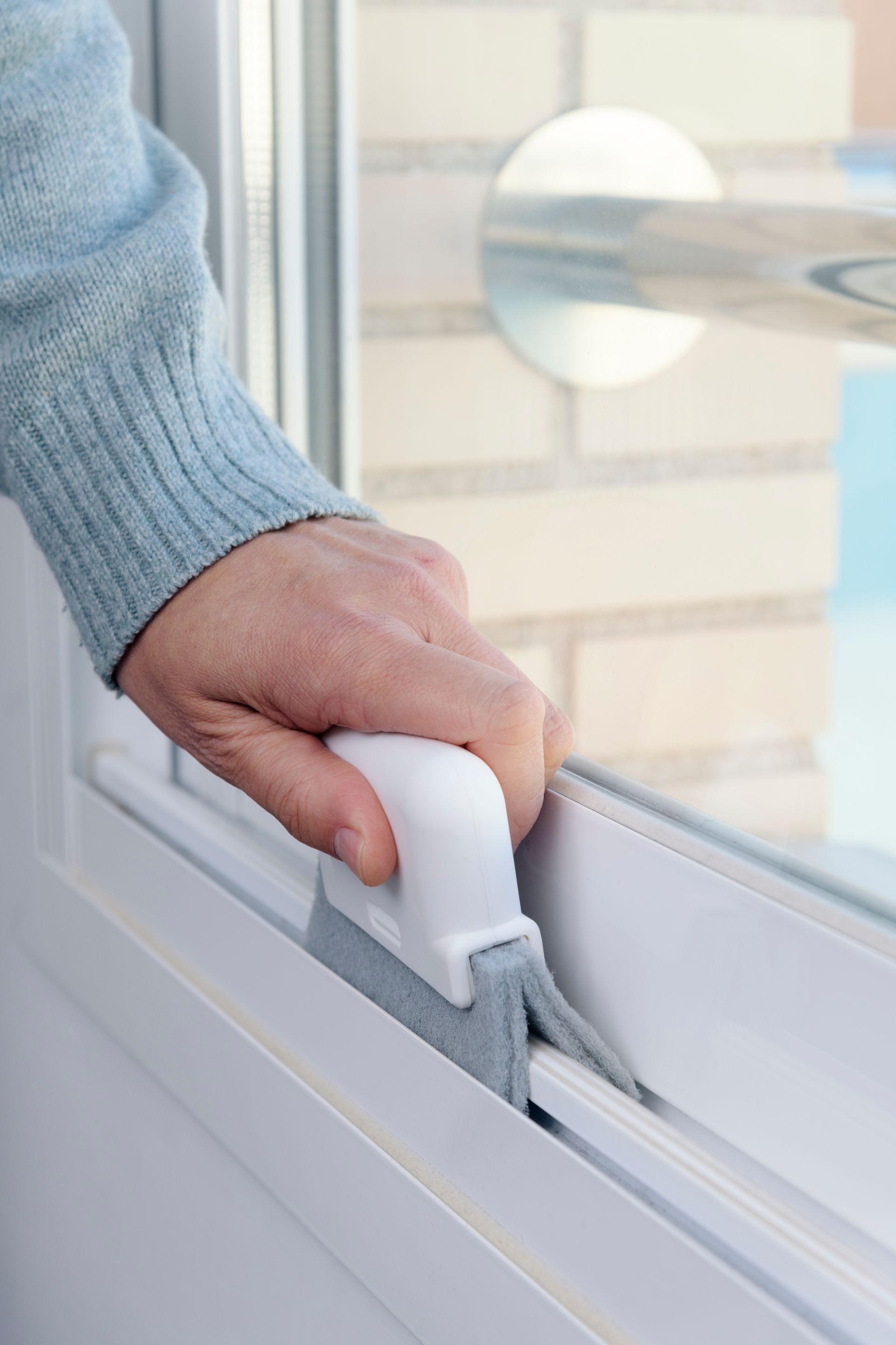 A person is cleaning a window with a brush.