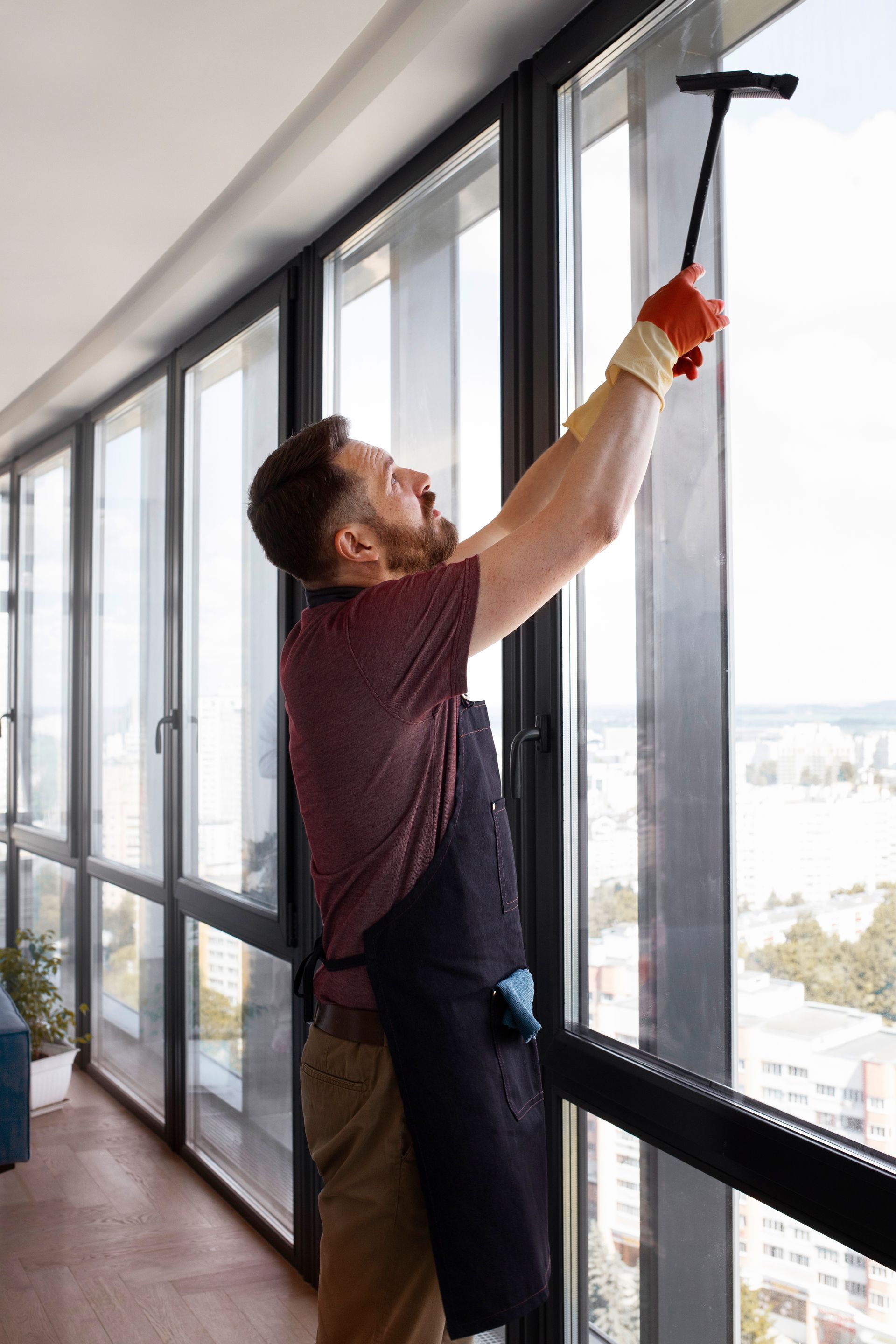 A man is cleaning a window with a squeegee.