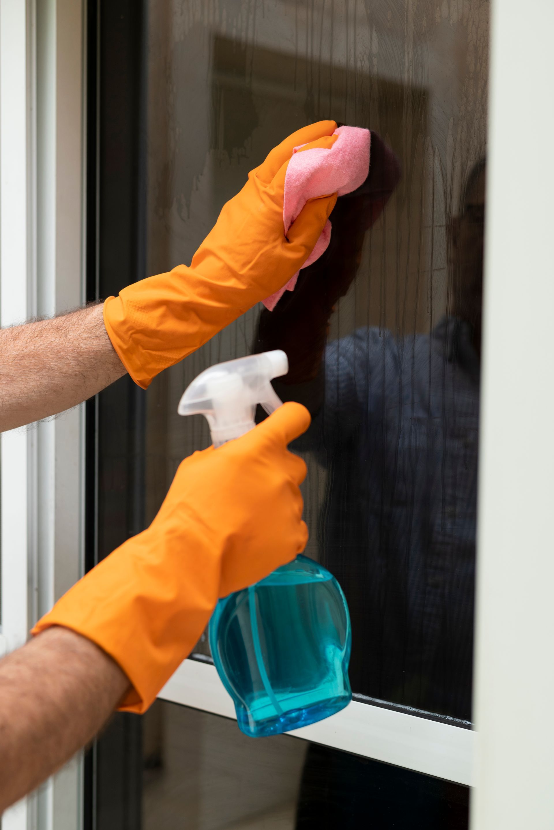 A man is cleaning a window with a squeegee.