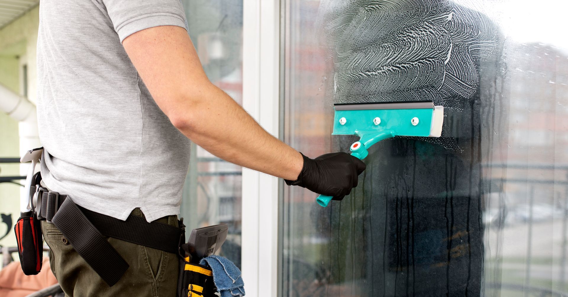 A man is cleaning a window with a squeegee.