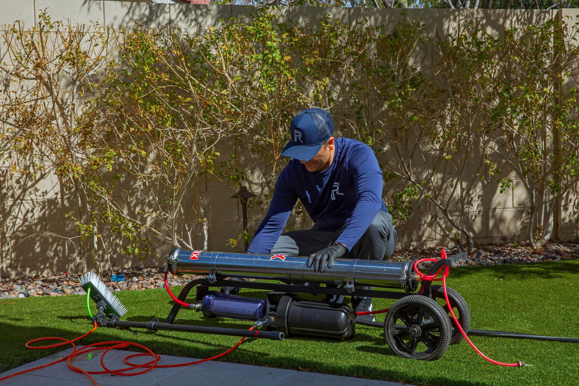 A man is working on a machine on a lawn.