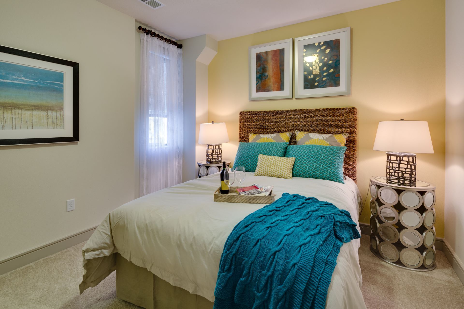 A bedroom with a bed , two lamps , and a picture on the wall.