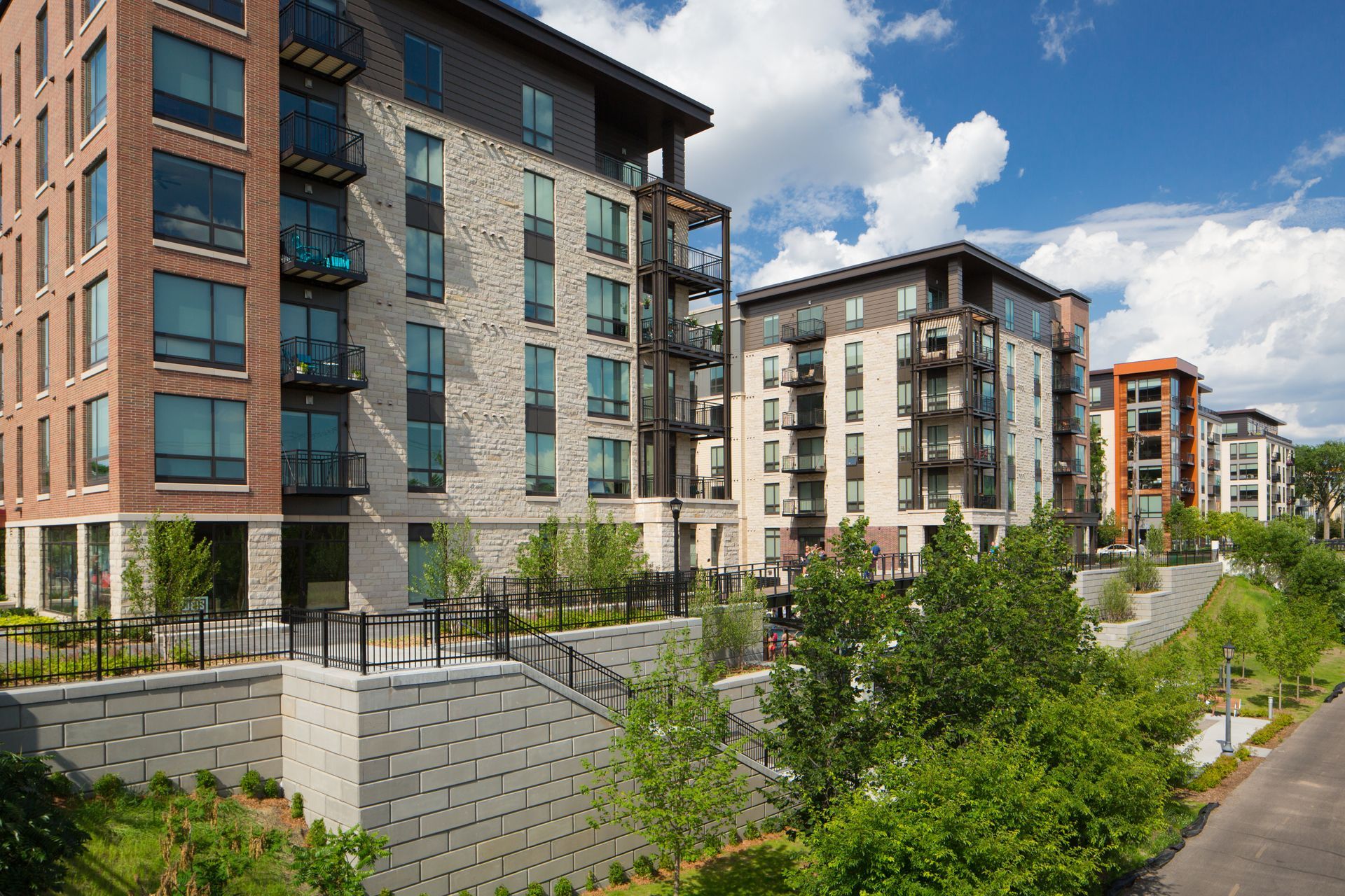 A row of apartment buildings with trees in front of them