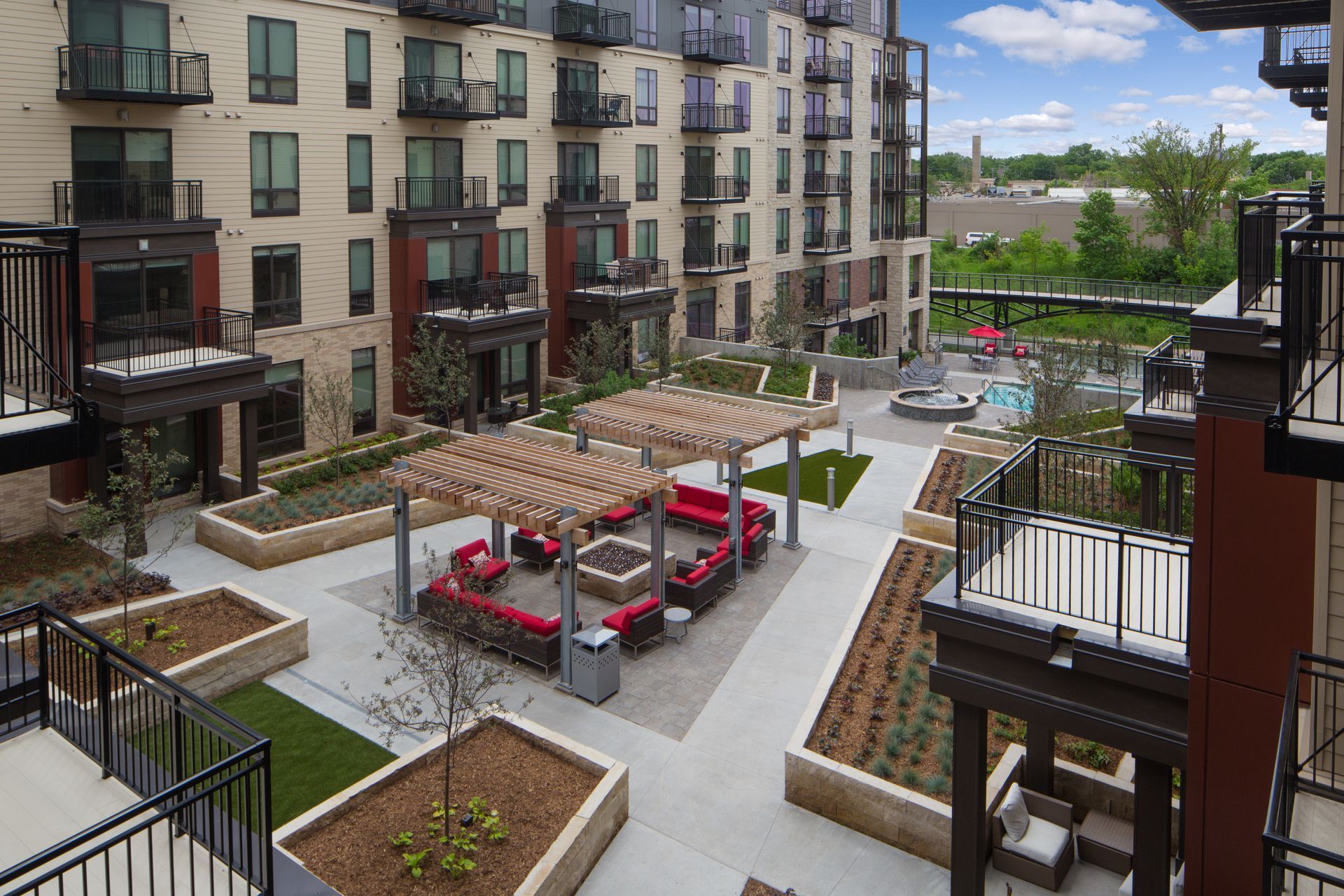 An aerial view of a large apartment building with a fire pit in the middle of the courtyard.