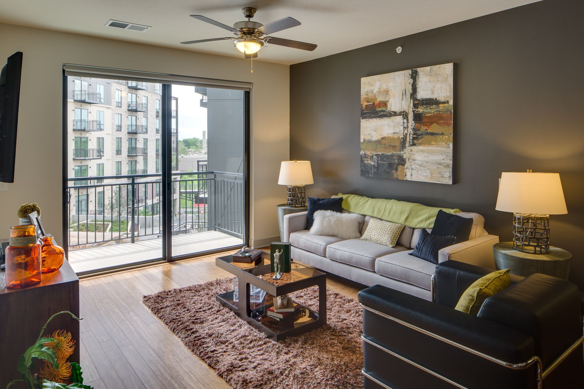 A living room with a couch a coffee table and a ceiling fan