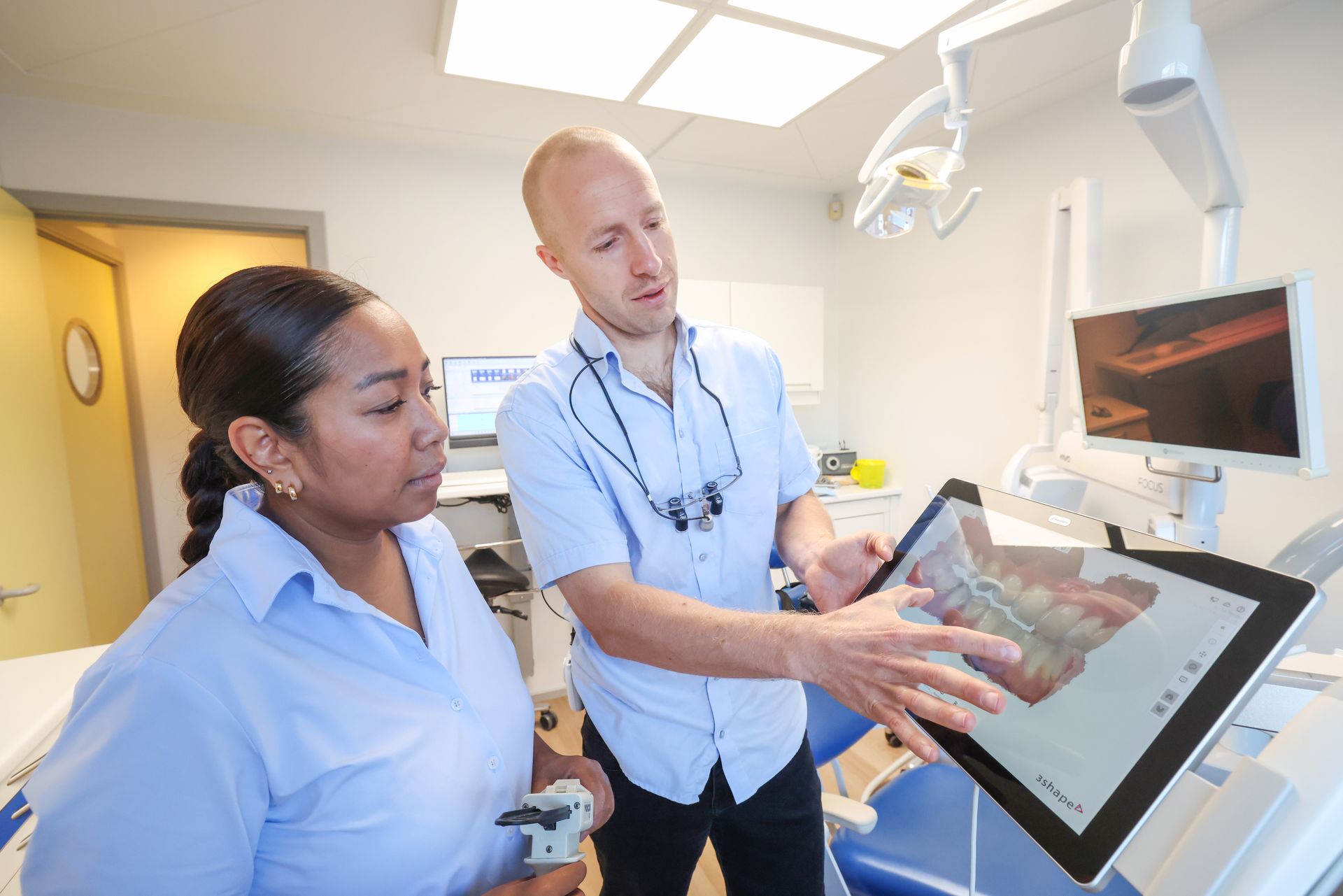 Tandlæge viser en patients 3d røntgenbillede af en tand