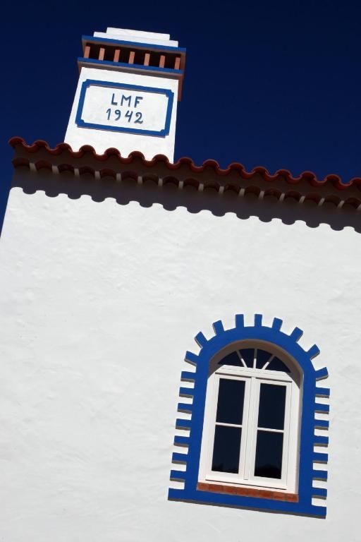 Prédio branco com detalhes em azul, chaminé com a inscrição 