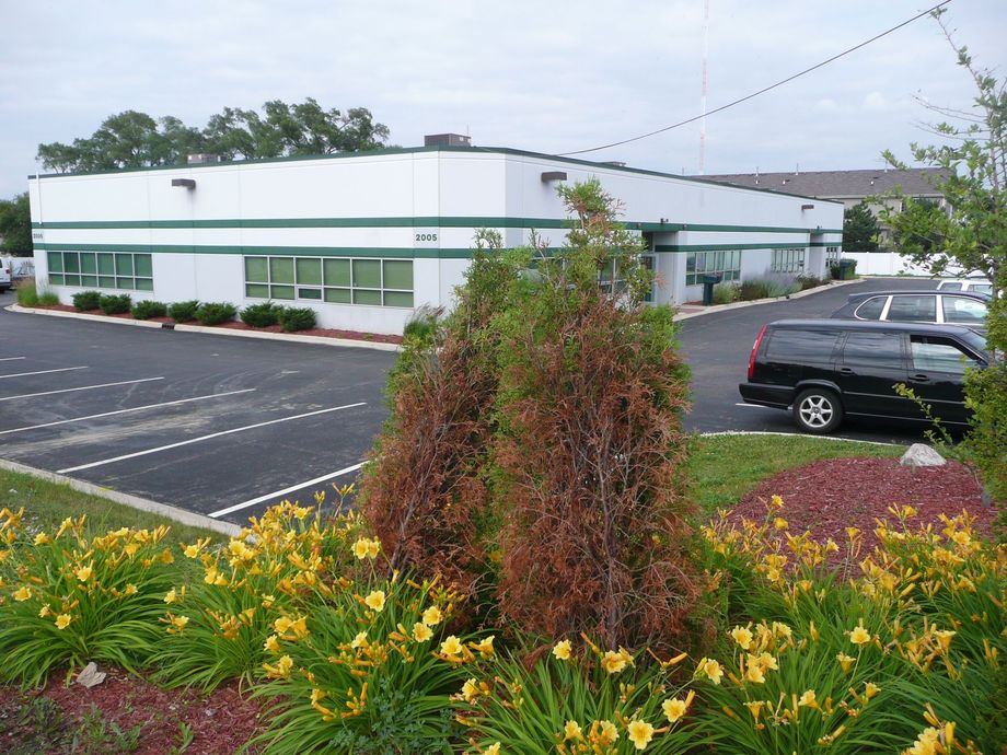 A black suv is parked in front of a white building