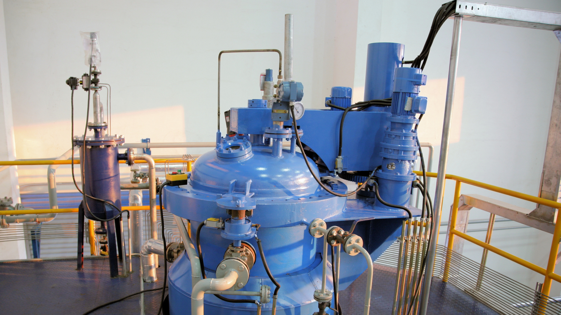 A factory with a lot of stainless steel tanks and pipes.